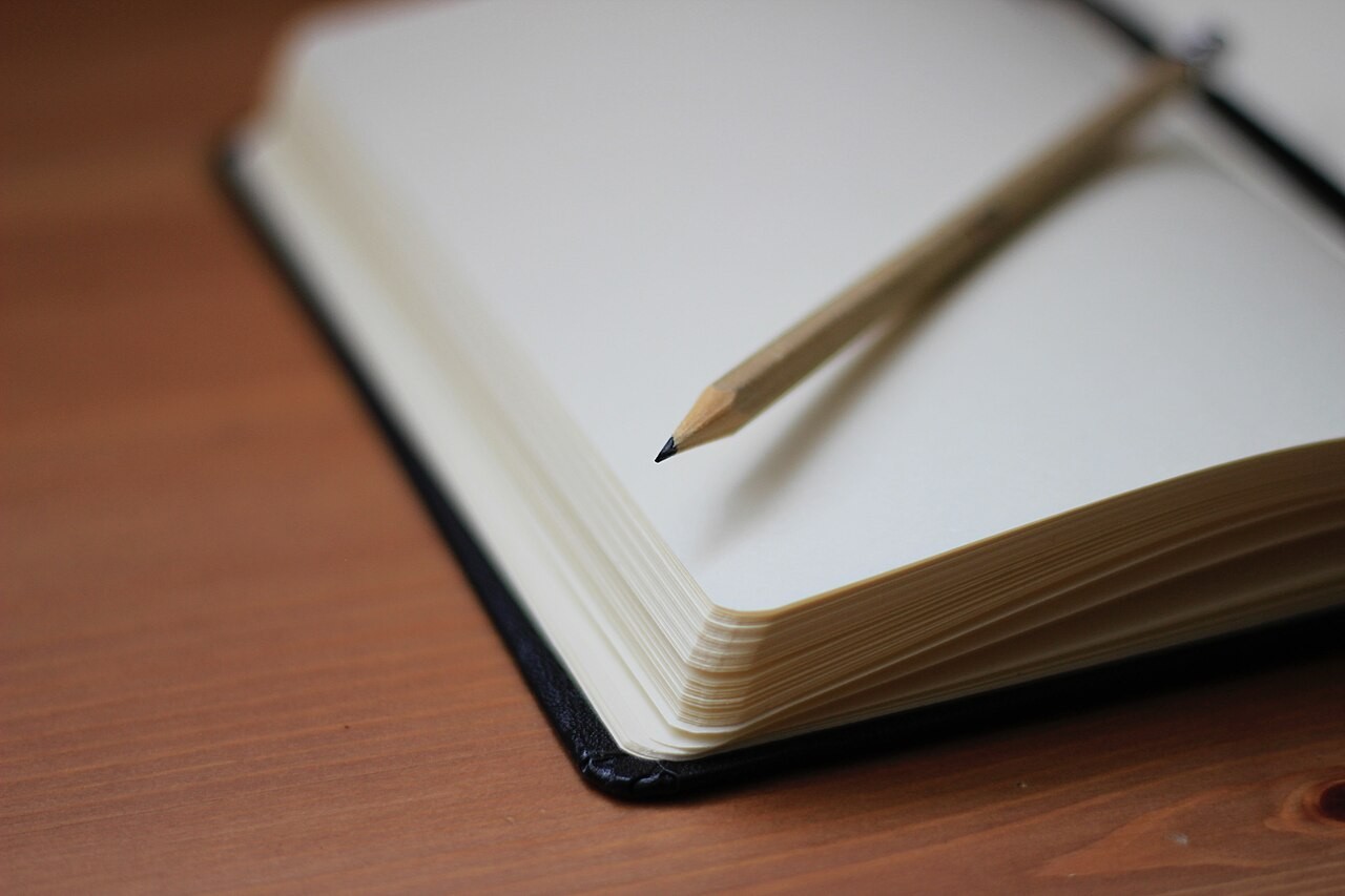 Otwarty notes i ołówek; zdjęcie poglądowe, nie przedstawia materiałów konkretnego projektu szkolnego.