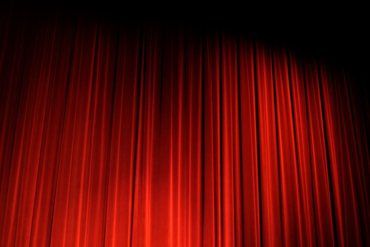 Czerwona kurtyna teatralna. Zdjęcie poglądowe; nie przedstawia sceny w Biskupcu ani spektaklu „Cudowna terapia”.