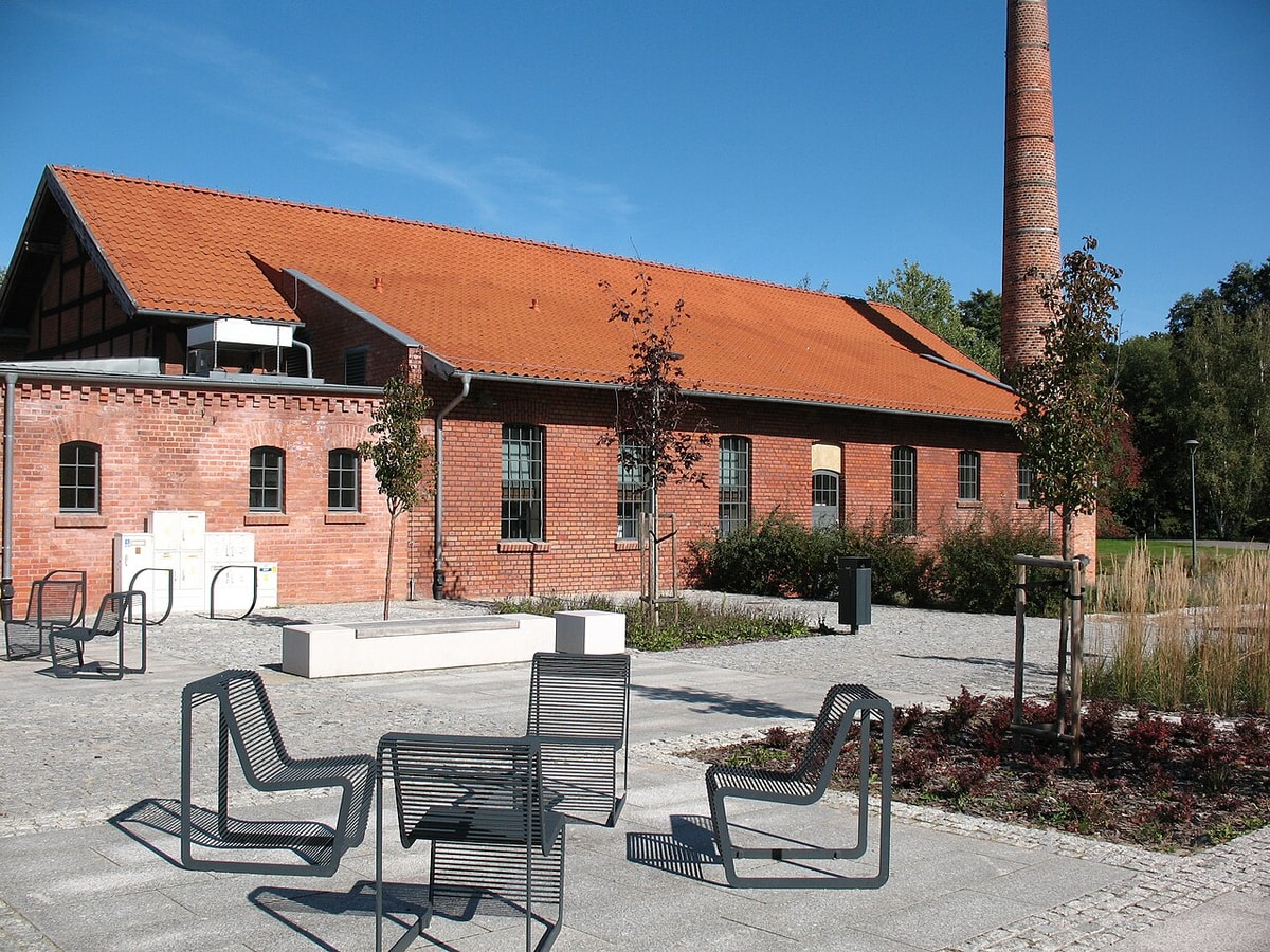 Krzesła i nasadzenia przed ceglaną elewacją Muzeum Nowoczesności w Parku Centralnym w Olsztynie; zdjęcie archiwalne z września 2020 roku.
