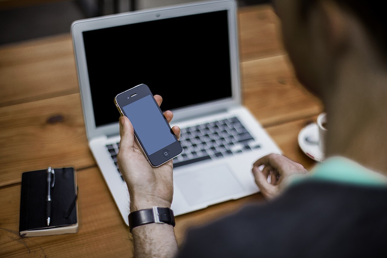 Korzystanie ze smartfona i laptopa. Zdjęcie poglądowe; nie przedstawia uczestników opisywanej sprawy.