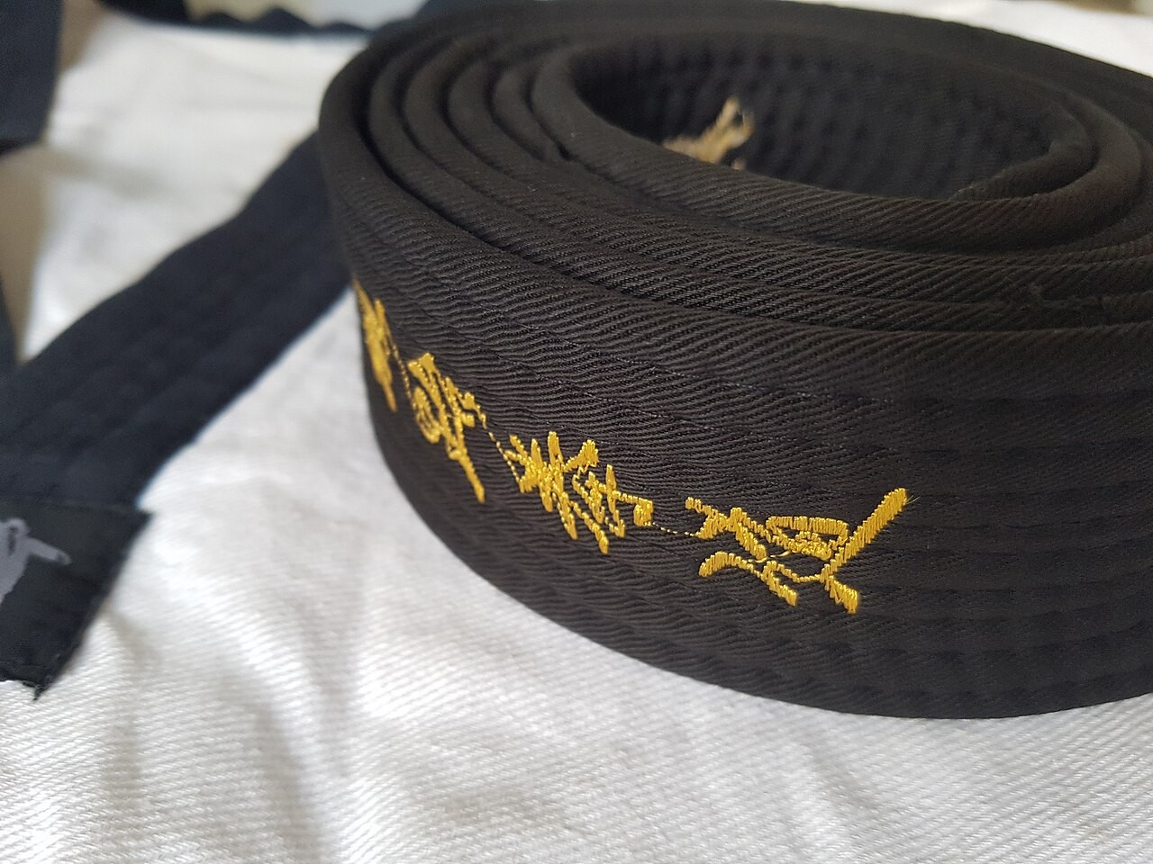 Czarny pas taekwondo, fotografia z Singapuru z 2018 roku. Zdjęcie poglądowe, nie przedstawia wyposażenia Szymona Piątkowskiego.