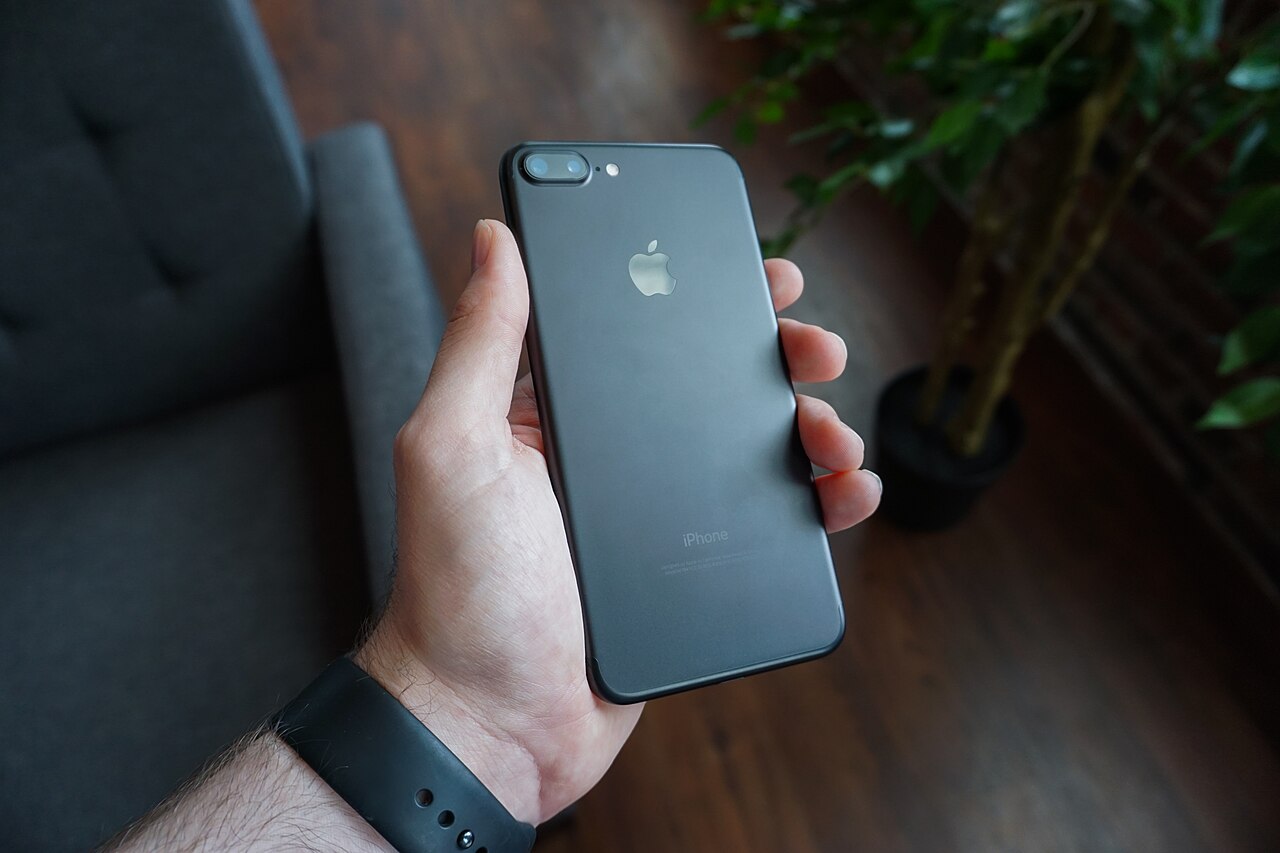 Smartfon trzymany w dłoni. Zdjęcie poglądowe; nie przedstawia interfejsu aplikacji Nasz Olsztyn.