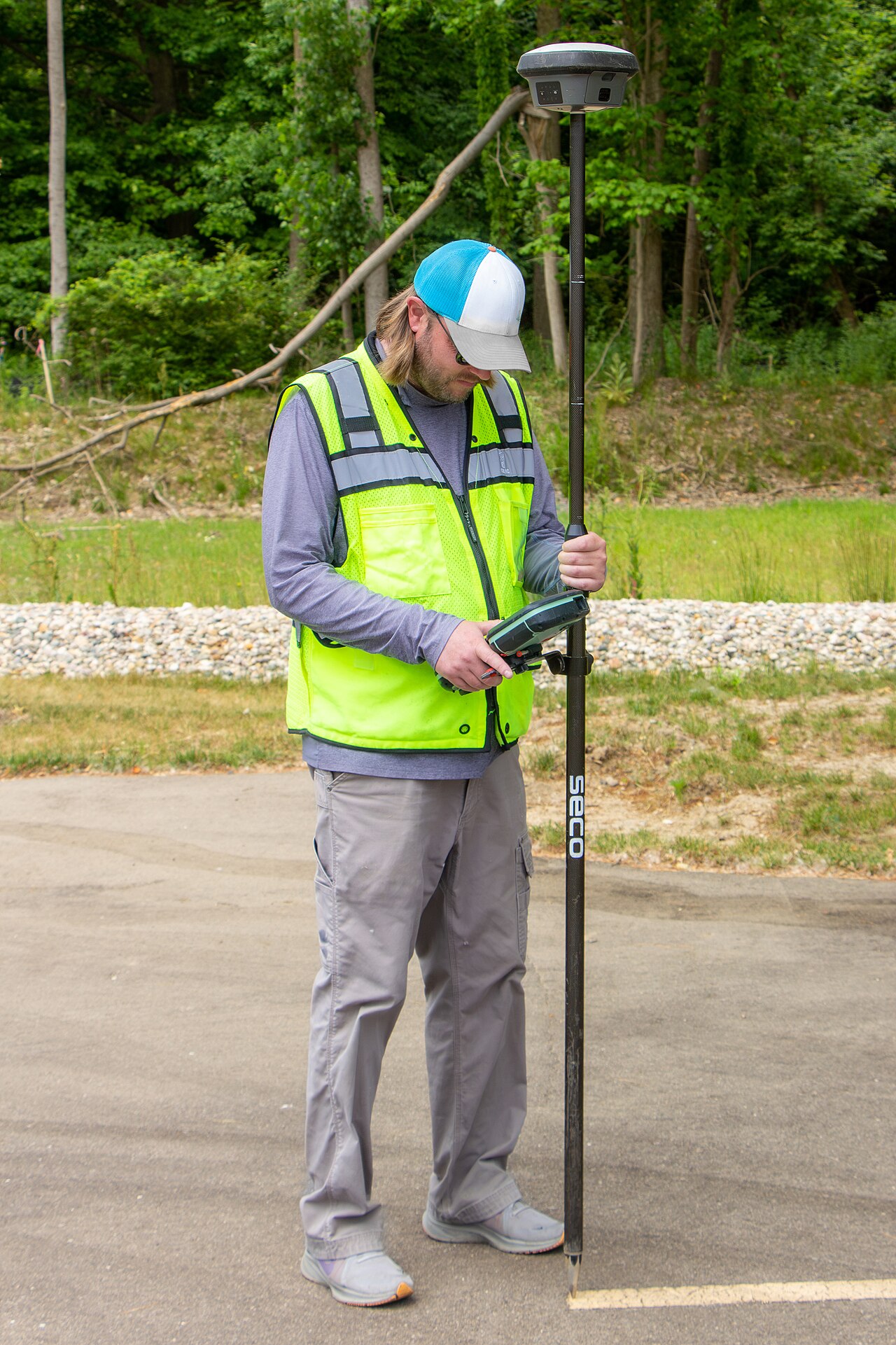 Geodeta wykonujący pomiary odbiornikiem GNSS z RTK, czerwiec 2023 roku. Zdjęcie poglądowe; nie przedstawia uczestników Geopodchodów w Kortowie.